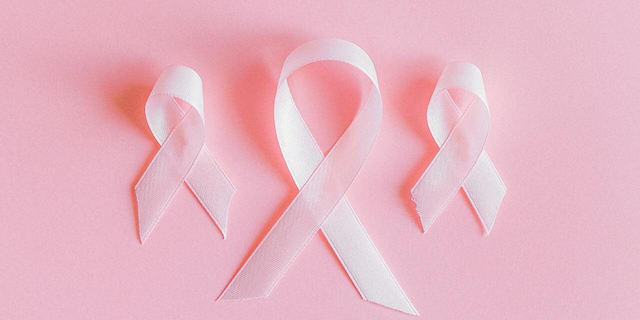 Roze lintjes borstkankerbewustzijn Drie roze lintjes symbool voor borstkankerbewustzijn op een roze achtergrond, passend bij het thema mammografie.
