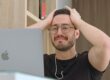Man met bril reageert gefrustreerd op laptop, mogelijk na een fout die per abuis is gemaakt