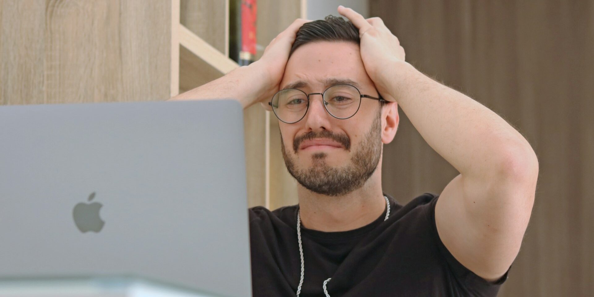 Fout per abuis ontdekt Man met bril reageert gefrustreerd op laptop, mogelijk na een fout die per abuis is gemaakt