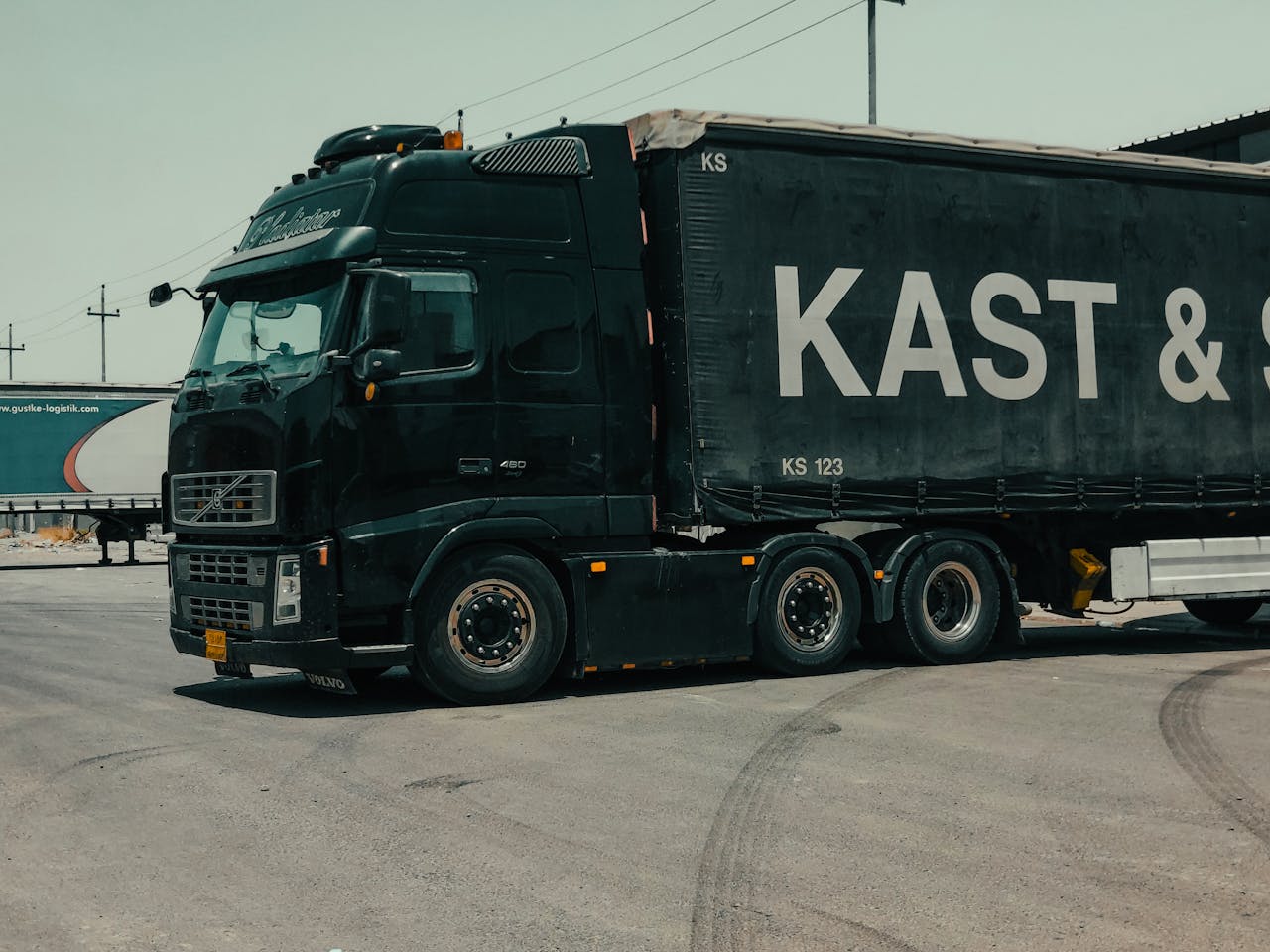 Zwarte vrachtwagen van logistiek bedrijf gereed voor same day delivery transport over de weg. 