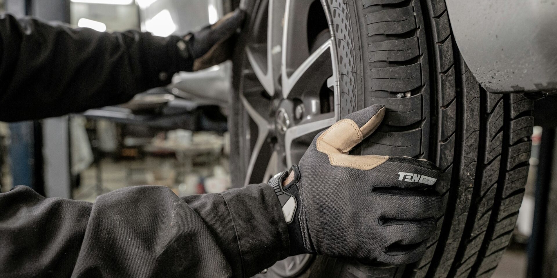 Monteur controleert autoband op slijtage en bandenspanning, essentieel voor TPMS en rijveiligheid