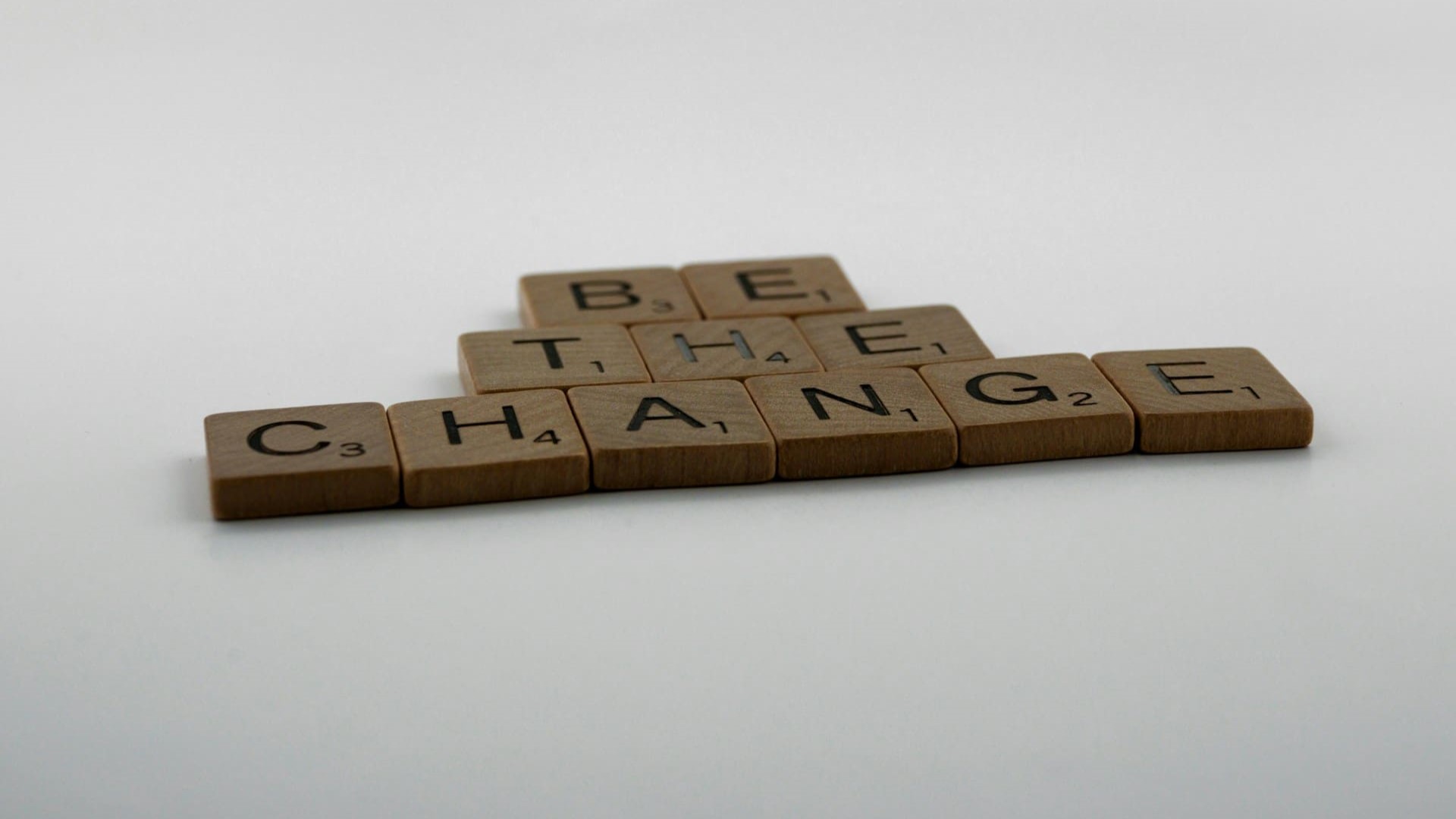 Scrabble-letters die samen ‘Be the change’ vormen – oproep tot proactief gedrag en persoonlijke verantwoordelijkheid.
