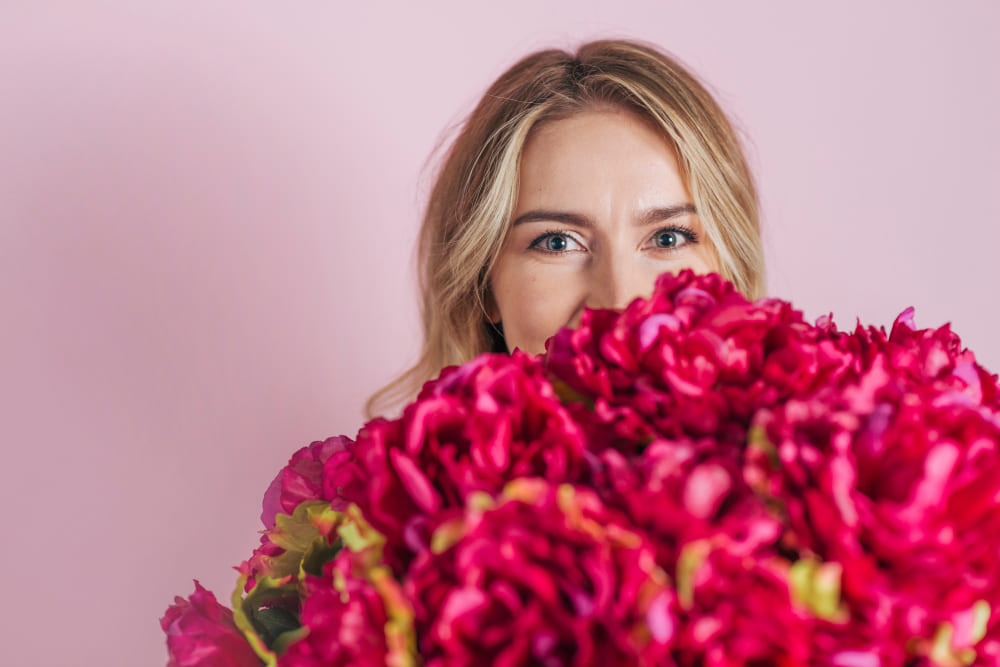 Vrouw met een grote bos roze bloemen
