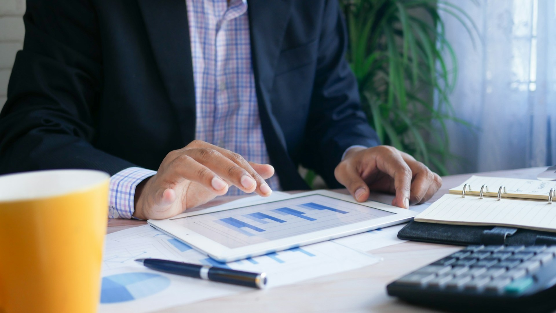 Medewerker analyseert grafieken op tablet bij voorbereiding lift huren Den Haag project