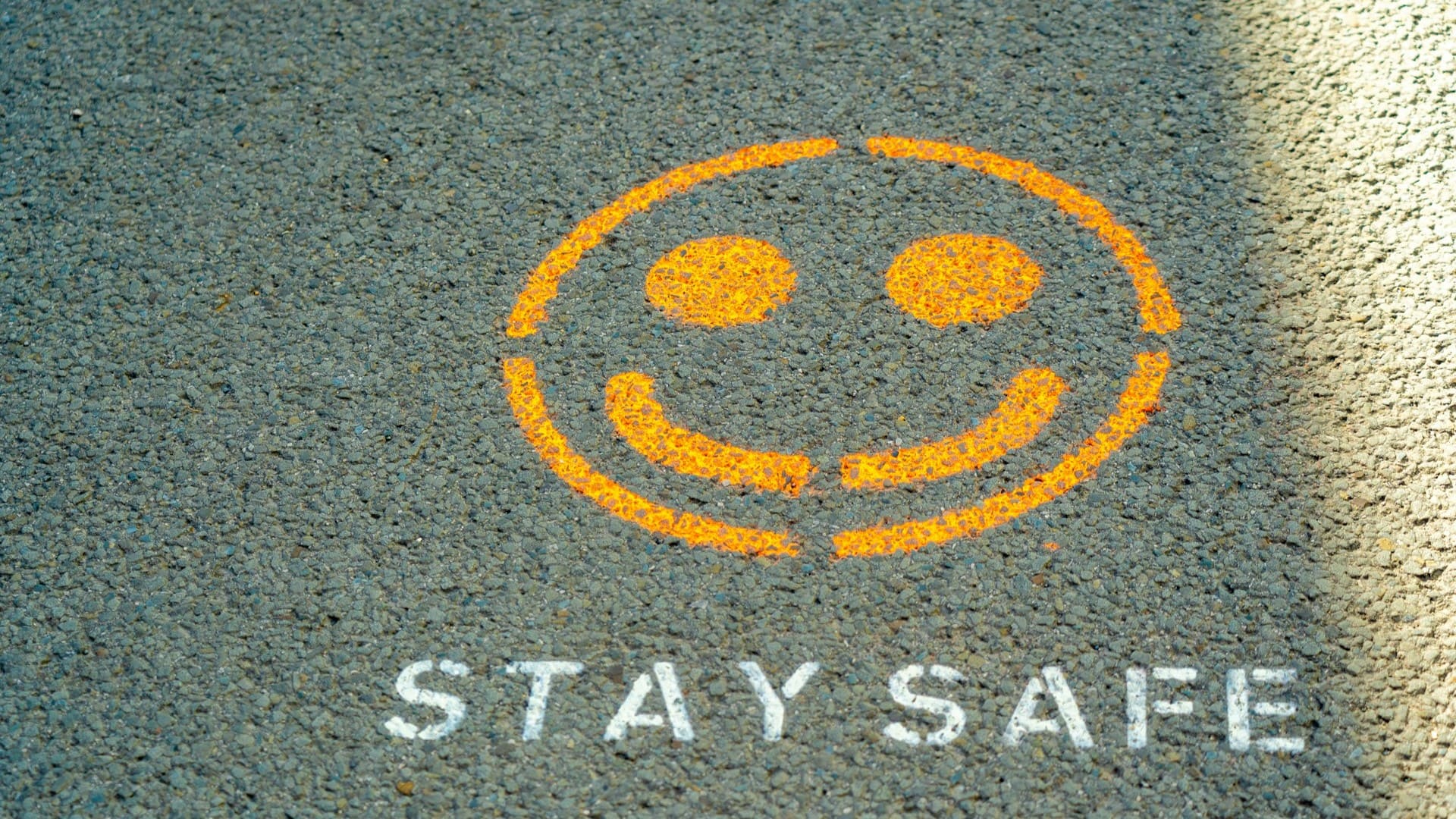 Oranje smiley met tekst ‘Stay Safe’ op asfalt als visuele verwijzing naar VCA-certificering en veilig werken