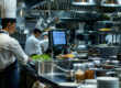 Professionele keuken met KDS systeem scherm dat bestellingen toont per station