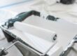 Verfroller met witte verf in verfbak tijdens schilderen voor een gelijkmatige dekking van de muur