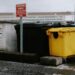 rolcontainers geel blauw en zwart langs weg