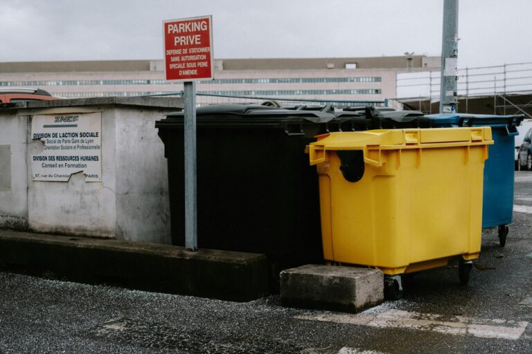 rolcontainers geel blauw en zwart langs weg