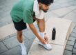 Hardloper strikt zijn schoenen voor een training waarbij stack height invloed heeft op comfort en demping