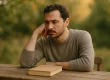 Persoon in denkhouding bij boek, betekenis reframing door innerlijke transformatie en mindshift